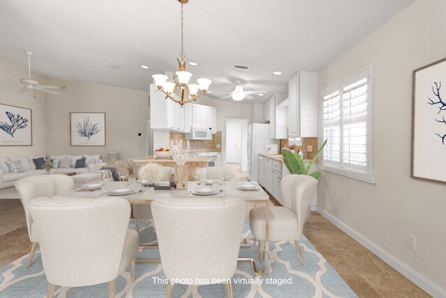 dining space featuring ceiling fan with notable chandelier and lofted ceiling