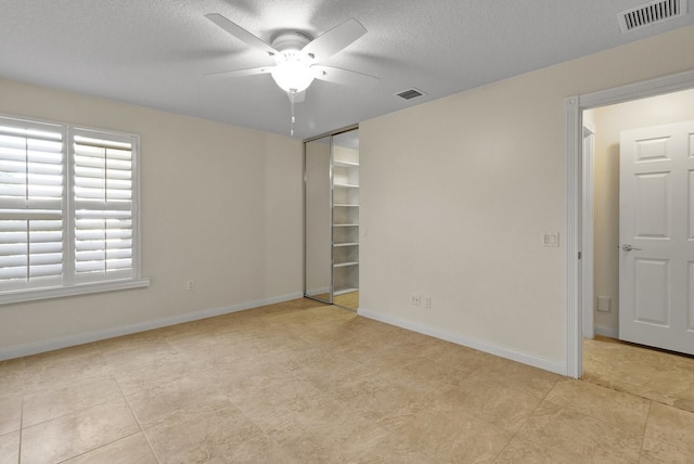 empty room featuring a textured ceiling and ceiling fan