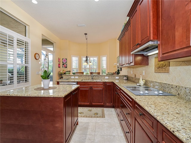 kitchen with light tile patterned floors, light stone countertops, hanging light fixtures, sink, and kitchen peninsula