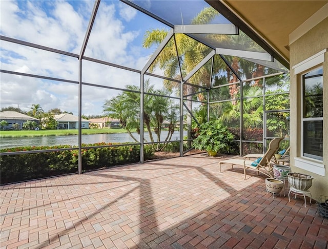 view of patio / terrace featuring a water view and glass enclosure