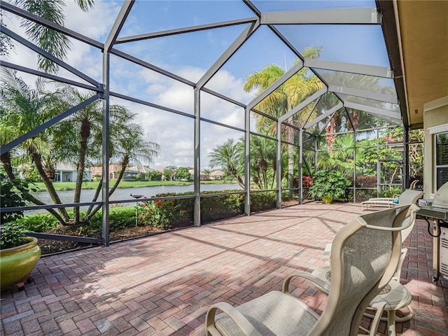 view of patio / terrace with glass enclosure and a water view