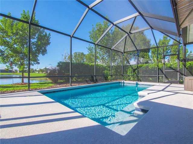 view of pool with a patio area, glass enclosure, and a water view