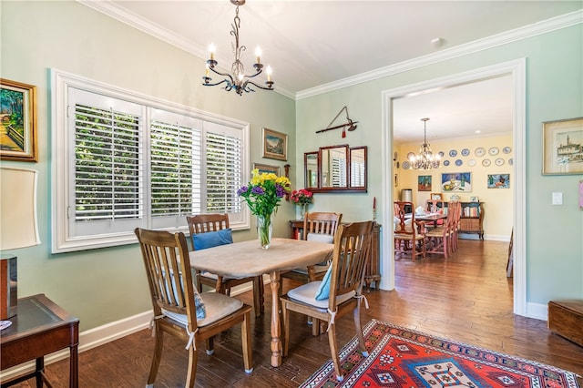 dining space with dark hardwood / wood-style flooring, ornamental molding, and an inviting chandelier