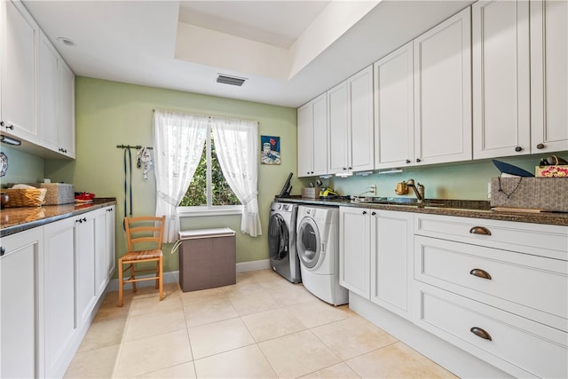 laundry area with light tile patterned flooring, cabinets, sink, and washing machine and clothes dryer