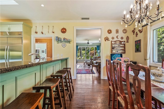 dining room featuring sink, dark hardwood / wood-style flooring, ceiling fan with notable chandelier, and ornamental molding