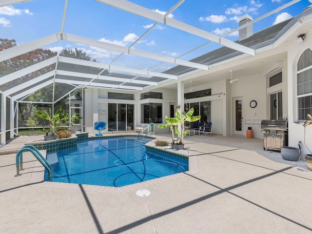 view of pool featuring glass enclosure, ceiling fan, and a patio area