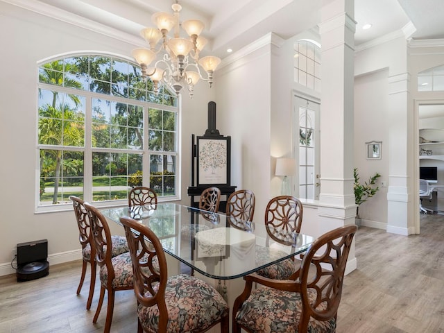 dining room featuring ornamental molding, an inviting chandelier, light hardwood / wood-style floors, and plenty of natural light