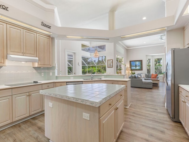 kitchen featuring black electric stovetop, a center island, stainless steel fridge with ice dispenser, sink, and light hardwood / wood-style flooring