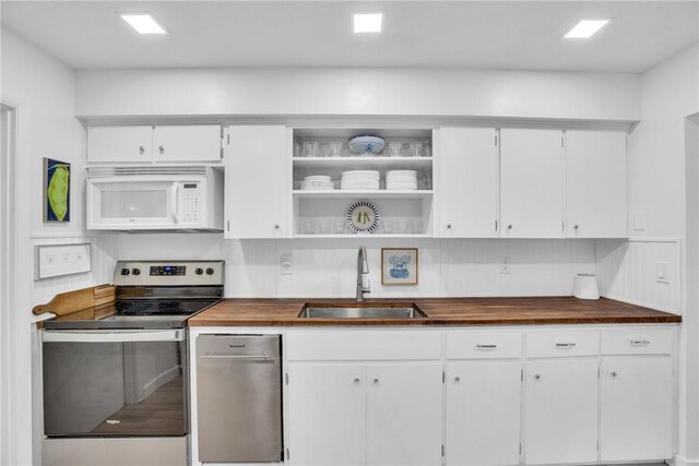 kitchen featuring white cabinetry, sink, electric range, and butcher block counters