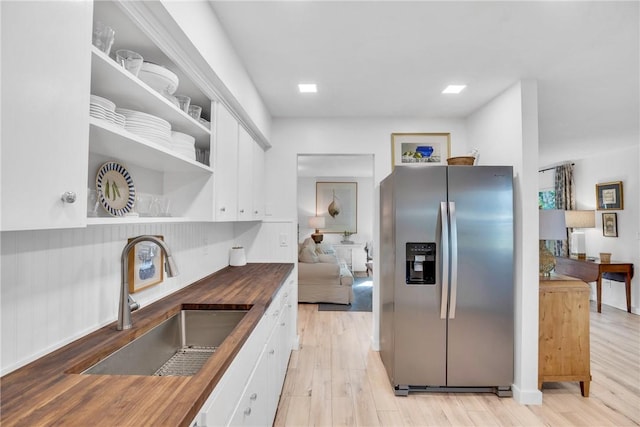 kitchen with white cabinets, butcher block countertops, and stainless steel fridge with ice dispenser