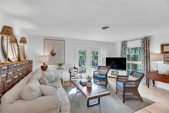 living room with light hardwood / wood-style flooring and french doors