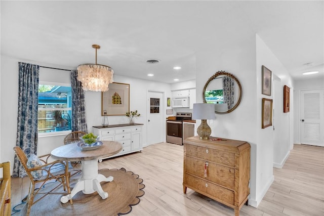 dining space featuring a chandelier and light wood-type flooring