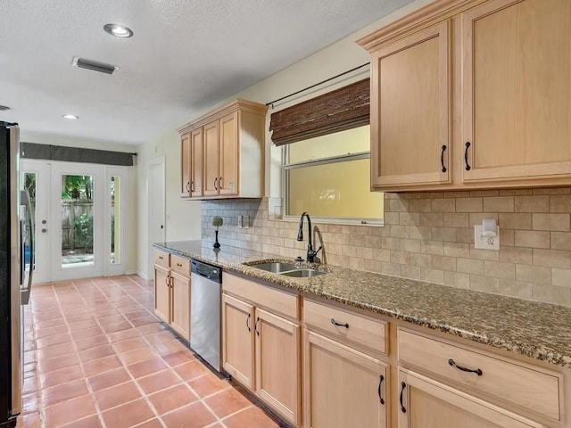 kitchen with appliances with stainless steel finishes, decorative backsplash, stone countertops, and sink