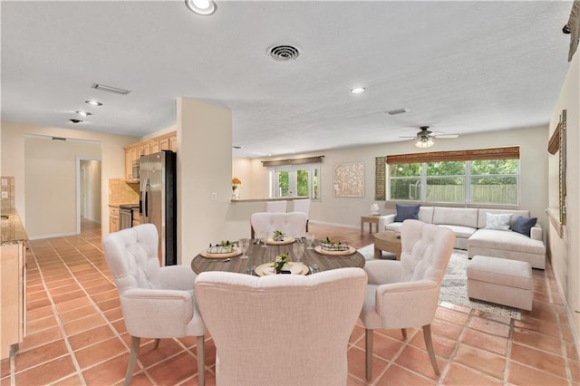 tiled dining room with ceiling fan and french doors