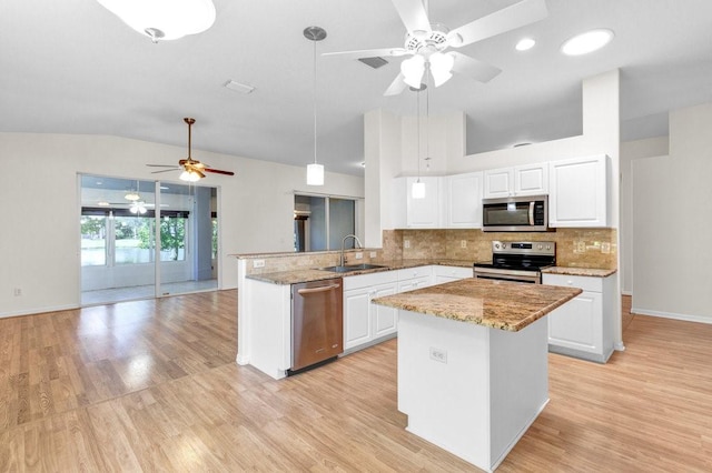 kitchen featuring light stone counters, a sink, white cabinetry, appliances with stainless steel finishes, and backsplash