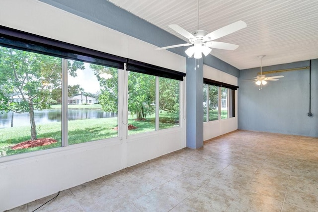 unfurnished sunroom featuring a water view and ceiling fan