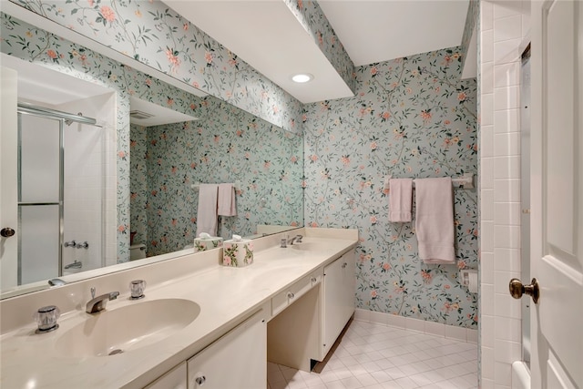 bathroom featuring vanity, a shower with shower door, and tile patterned flooring