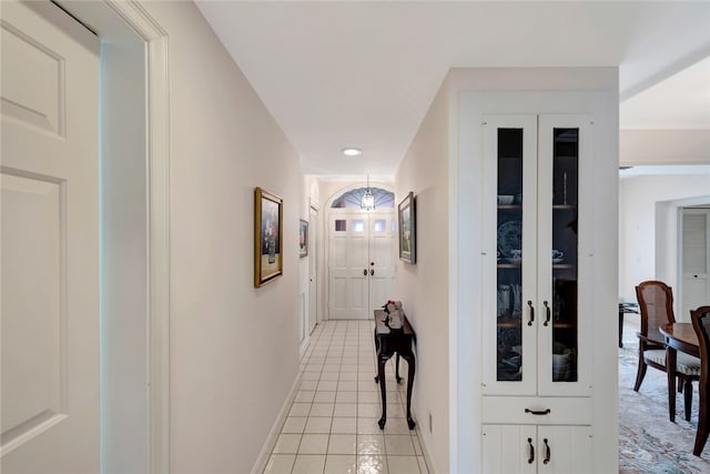 corridor featuring light tile patterned floors and french doors