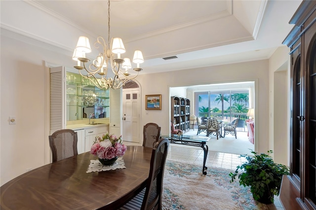 dining room with sink, a notable chandelier, and ornamental molding