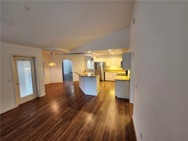 3865 8th Pl, Vero Beach, FL 32960 - kitchen featuring stainless steel fridge with ice dispenser, arched walkways, dark wood-type flooring, white cabinetry, and recessed lighting