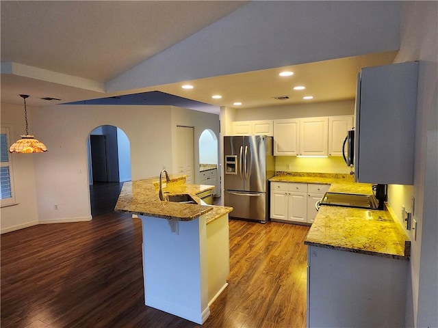 3865 8th Pl, Vero Beach, FL 32960 - kitchen featuring stainless steel refrigerator with ice dispenser, range with electric stovetop, arched walkways, wood finished floors, and light stone countertops