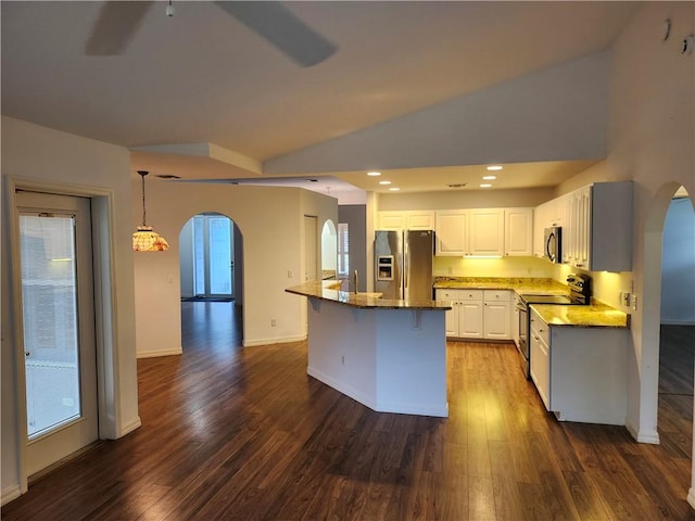 3865 8th Pl, Vero Beach, FL 32960 - kitchen featuring arched walkways, stainless steel appliances, dark wood-style floors, lofted ceiling, and white cabinets
