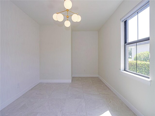 4348 Beauty Leaf Cir, Vero Beach, FL 32967 - spare room featuring a healthy amount of sunlight, a notable chandelier, marble finish floor, and baseboards