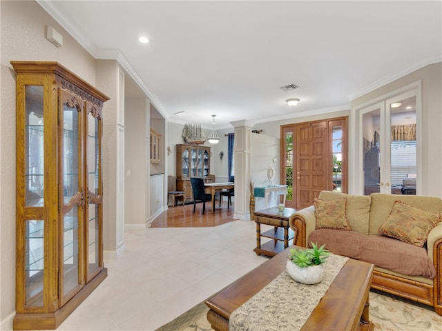 living room featuring decorative columns, light tile patterned flooring, and ornamental molding