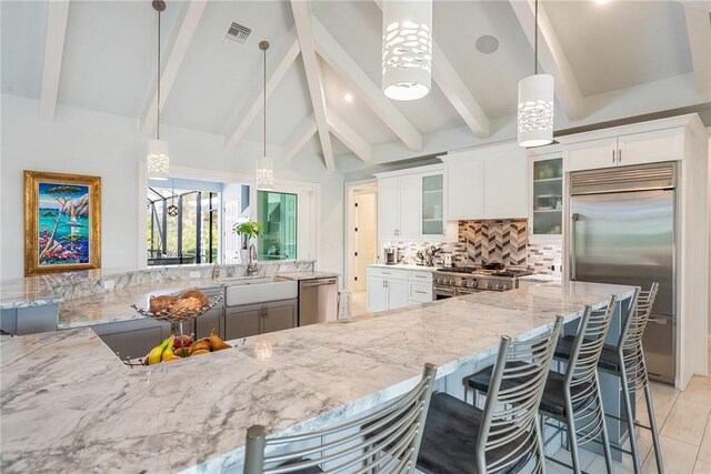 951 W Polo Grounds Dr, Vero Beach, FL 32966 - kitchen with stainless steel appliances, tasteful backsplash, light stone countertops, and a kitchen breakfast bar