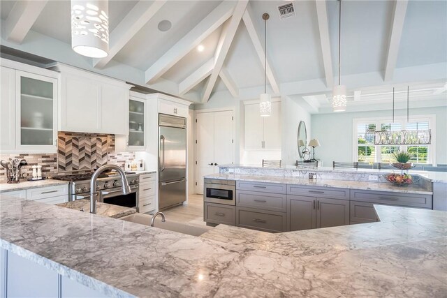 951 W Polo Grounds Dr, Vero Beach, FL 32966 - kitchen with high quality appliances, light stone countertops, decorative backsplash, and white cabinetry