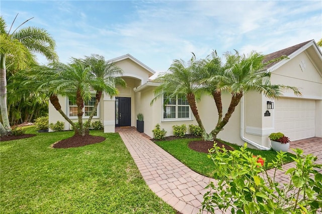 view of front facade featuring a garage, a front yard, and stucco siding