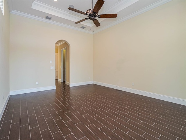 spare room with ceiling fan, a raised ceiling, dark hardwood / wood-style floors, and crown molding