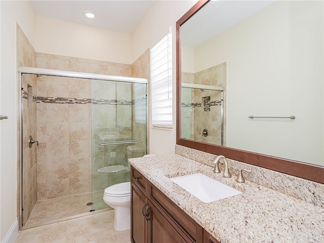 bathroom featuring a shower with shower door, vanity, toilet, and tile patterned flooring