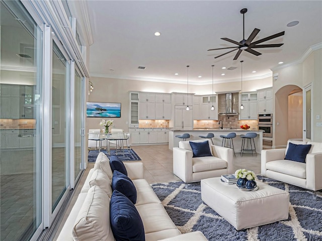 tiled living room with ceiling fan and ornamental molding