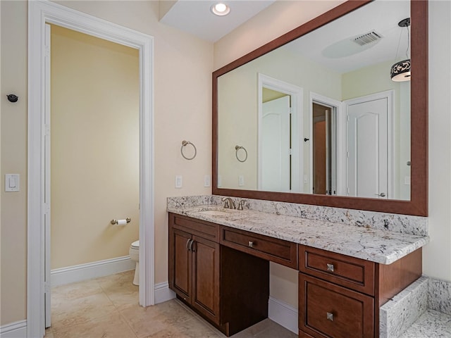 bathroom featuring vanity, tile patterned floors, and toilet