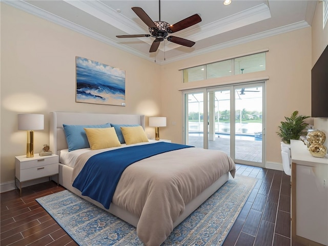 bedroom featuring ornamental molding, ceiling fan, a tray ceiling, dark hardwood / wood-style flooring, and access to outside