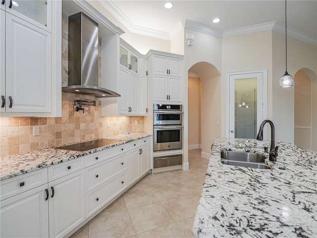 kitchen featuring white cabinets, wall chimney exhaust hood, pendant lighting, and black electric stovetop