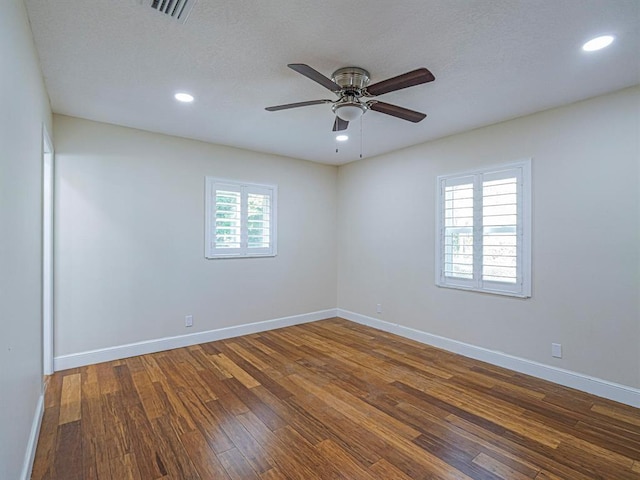 empty room featuring ceiling fan, dark hardwood / wood-style flooring, and a textured ceiling