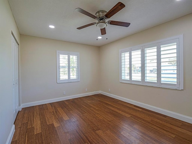 empty room with dark hardwood / wood-style floors, a textured ceiling, and ceiling fan