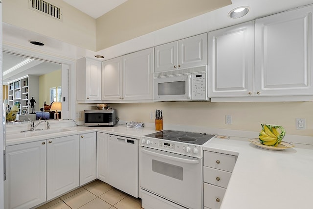 kitchen with white cabinetry, white appliances, sink, and light tile patterned floors