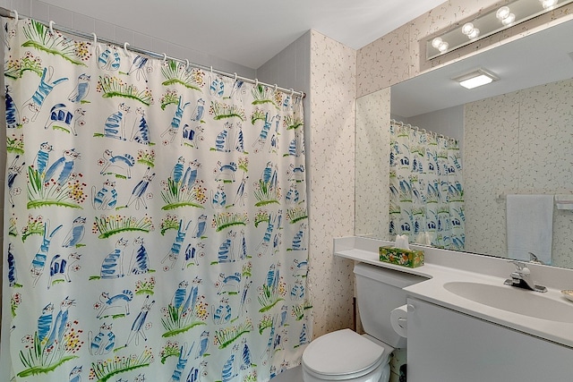 bathroom featuring walk in shower, vanity, and toilet