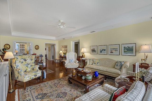 living room with ornamental molding, dark hardwood / wood-style floors, a raised ceiling, and ceiling fan