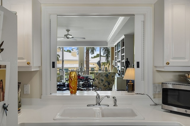 kitchen with white cabinetry, sink, and ceiling fan