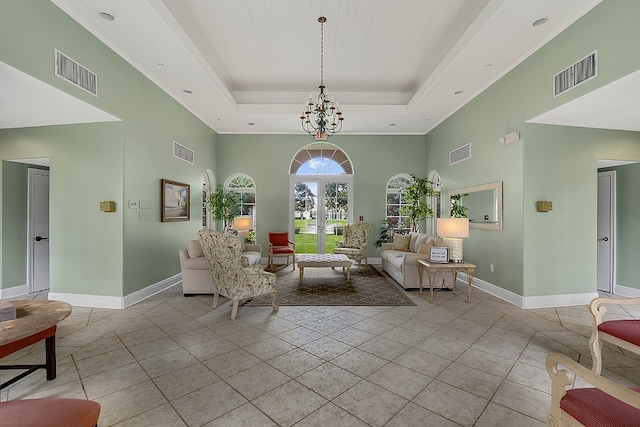 living room featuring a chandelier, a towering ceiling, light tile patterned floors, and a raised ceiling