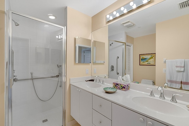 bathroom featuring toilet, vanity, and a shower with door