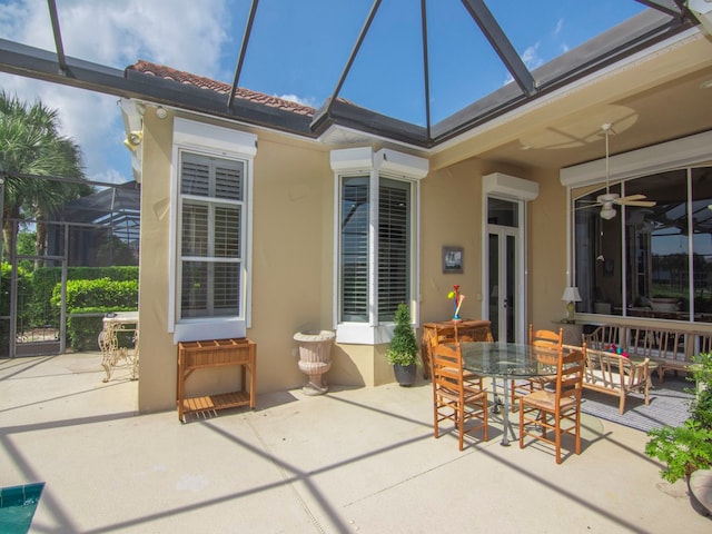 view of patio / terrace featuring glass enclosure, ceiling fan, and a wall mounted air conditioner