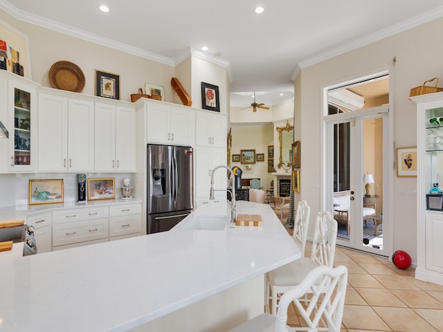 kitchen featuring stainless steel appliances, white cabinetry, sink, ceiling fan, and crown molding