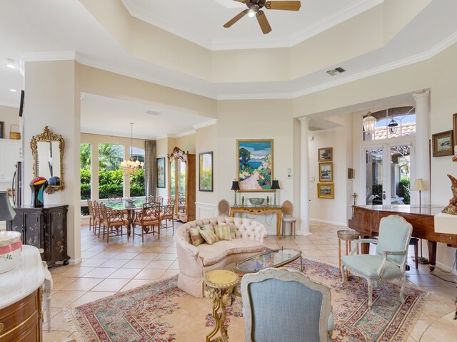 tiled living room with ornamental molding, ceiling fan with notable chandelier, and ornate columns