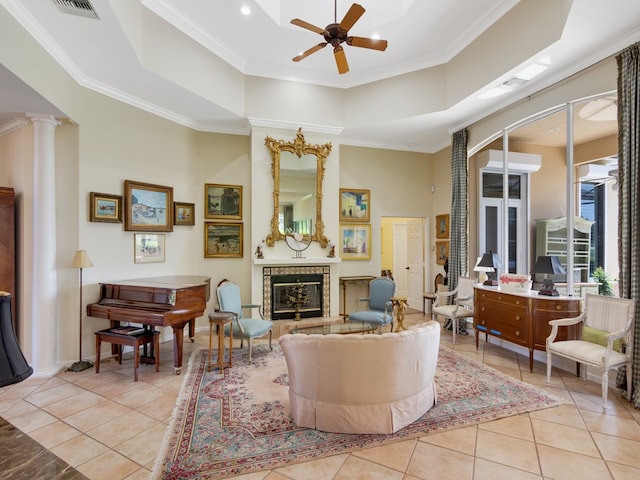 tiled living room with a high ceiling, ceiling fan, ornate columns, and crown molding