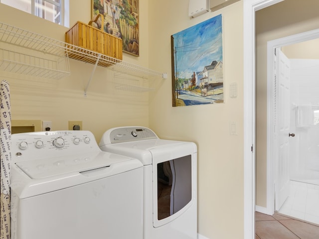 laundry area with a wall unit AC, light tile patterned flooring, and washer and dryer